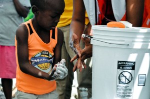 World Vision (Federal Way, Wash.) demonstrates the importance of handwashing to a young boy from camp Haut la Grotte in Haiti. Photo courtesy Lisa Salyer, World Vision.