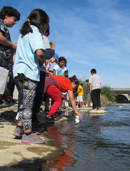 Sunrise Elementary School students collect water from the Los Angeles River for an Earth Echo WWMC event to learn how to test, monitor, and improve water quality. Photo courtesy of EarthEcho International.