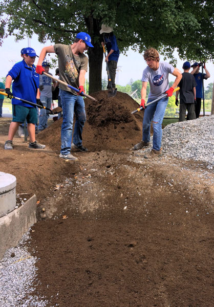 Boy Scouts work together to move soil in preparation to place plants in the rain garden. WEF photo/Caroline Pakenham. 