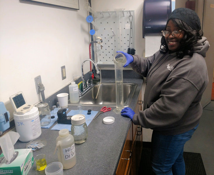 April Langhorne, HRSD apprentice, collects a daily final effluent sample for testing. Photo courtesy of HRSD.